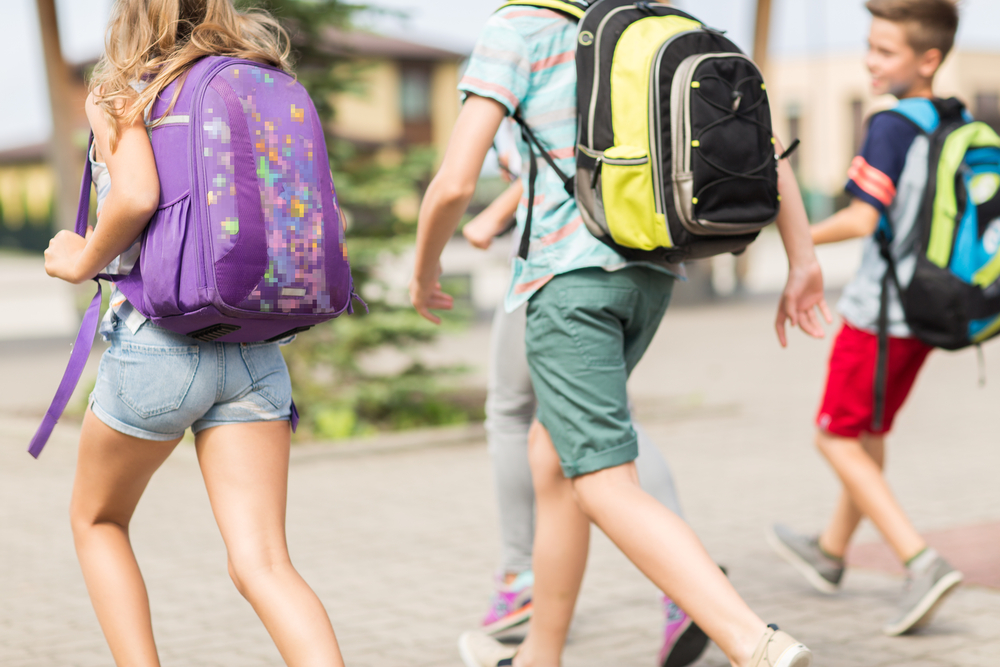 Grupo de niños de educación primera con mochilas